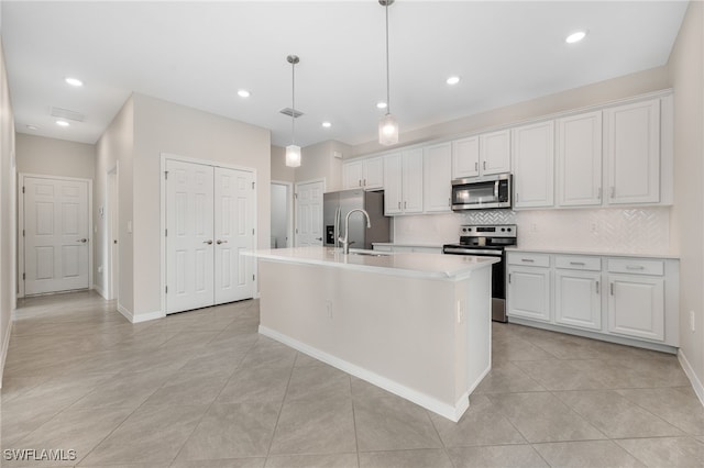 kitchen with hanging light fixtures, appliances with stainless steel finishes, white cabinets, and light countertops