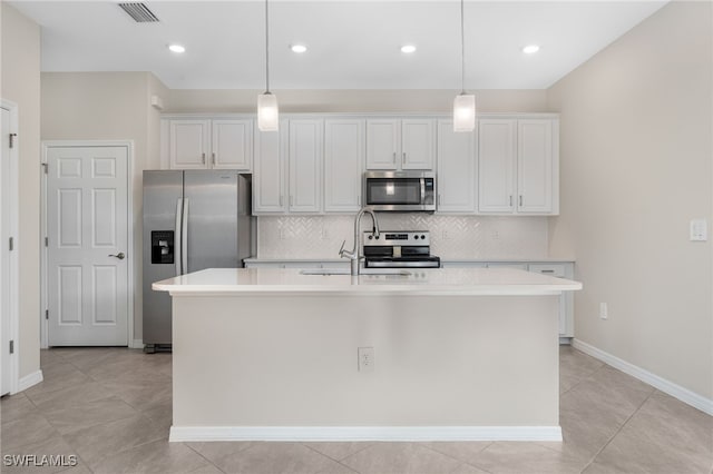 kitchen with visible vents, an island with sink, appliances with stainless steel finishes, light countertops, and pendant lighting