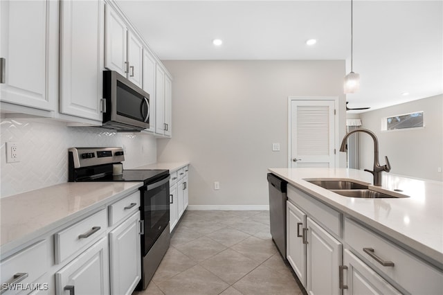 kitchen with a sink, white cabinetry, hanging light fixtures, appliances with stainless steel finishes, and backsplash