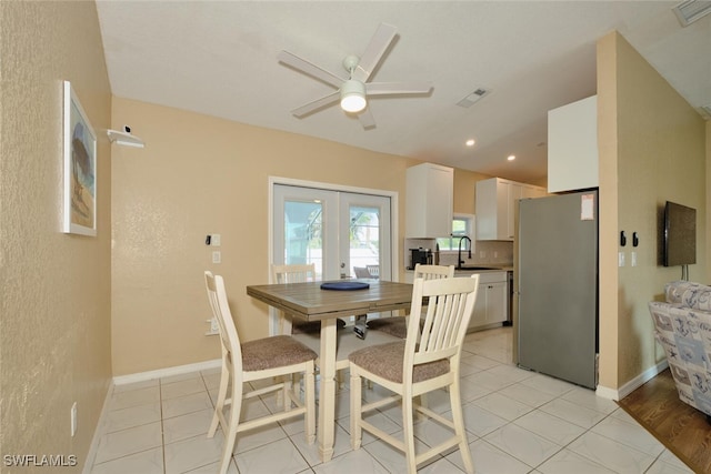 dining space with light tile patterned floors, french doors, visible vents, and baseboards