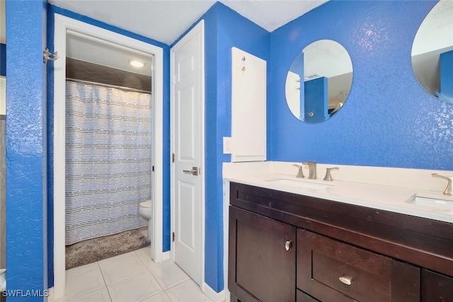 full bathroom featuring toilet, double vanity, a sink, and a shower with shower curtain