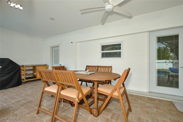 dining room featuring brick floor and ceiling fan