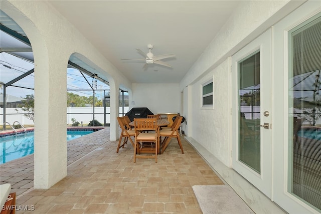 sunroom with ceiling fan and a pool