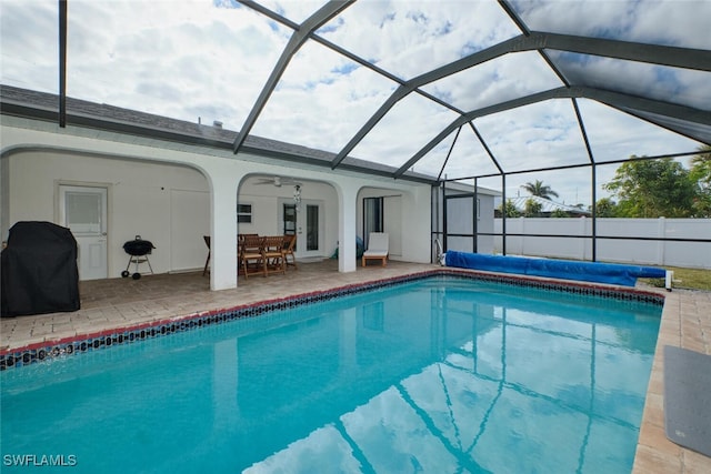 view of pool featuring glass enclosure, a grill, and a fenced in pool