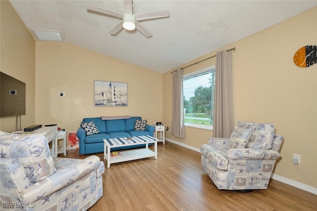 living area featuring lofted ceiling, light wood-style floors, baseboards, and a ceiling fan