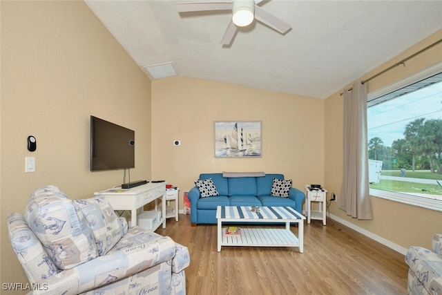 living room with light wood-type flooring, lofted ceiling, baseboards, and a ceiling fan