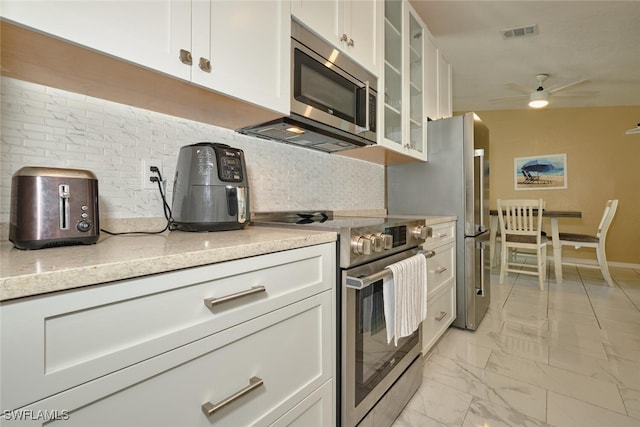 kitchen with glass insert cabinets, stainless steel appliances, and white cabinetry