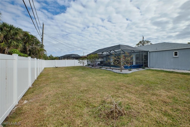 view of yard featuring a fenced in pool, glass enclosure, and a fenced backyard