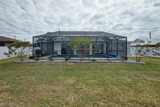 rear view of property featuring a yard, a fenced backyard, a lanai, and an outdoor pool