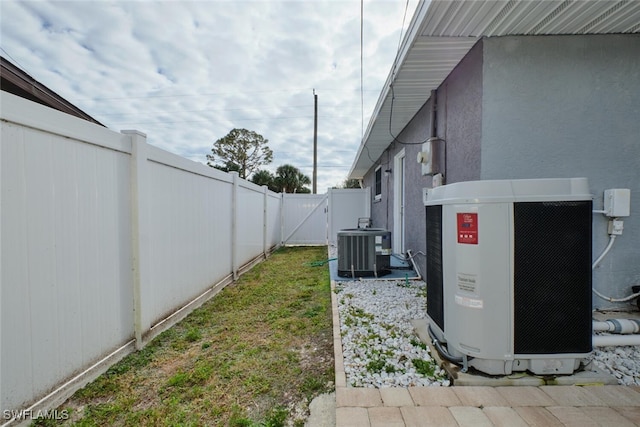 view of yard featuring a gate, a fenced backyard, and central AC unit