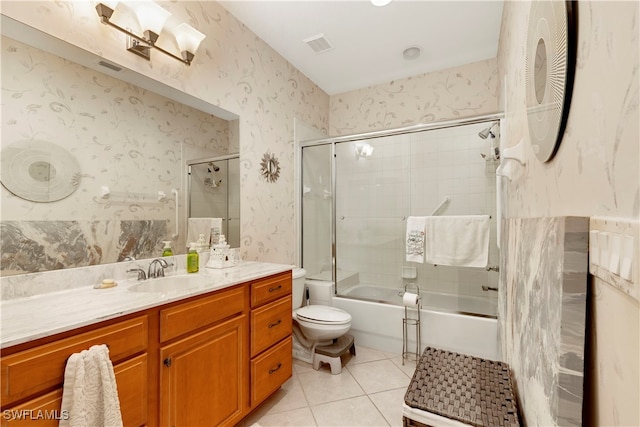 bathroom featuring bath / shower combo with glass door, toilet, vanity, tile patterned flooring, and wallpapered walls