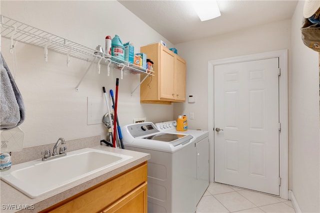 clothes washing area featuring light tile patterned floors, independent washer and dryer, a sink, and cabinet space