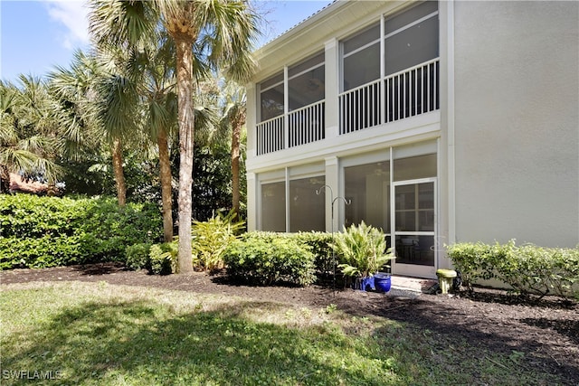 exterior space with a sunroom and stucco siding