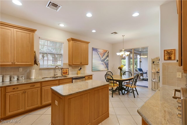 kitchen with a center island, decorative light fixtures, a sink, and visible vents