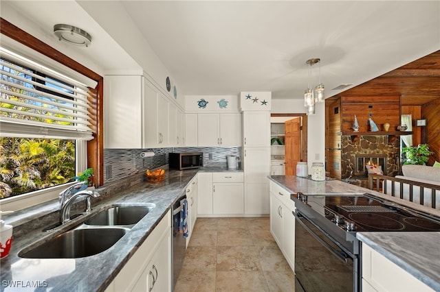 kitchen with pendant lighting, stainless steel appliances, decorative backsplash, white cabinets, and a sink