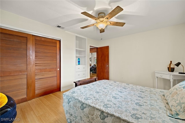 bedroom with light wood finished floors, a closet, visible vents, and a ceiling fan