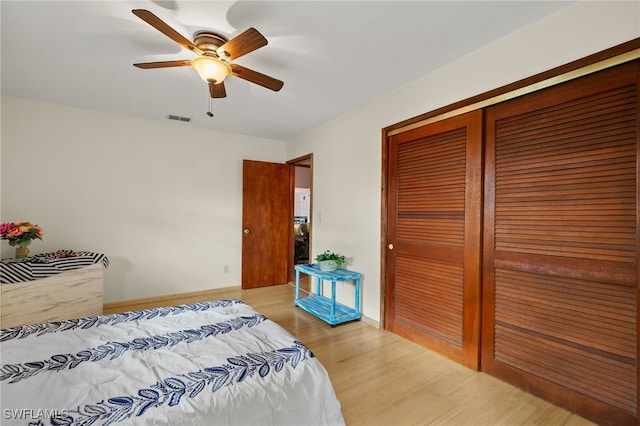 bedroom featuring baseboards, visible vents, a ceiling fan, light wood-type flooring, and a closet