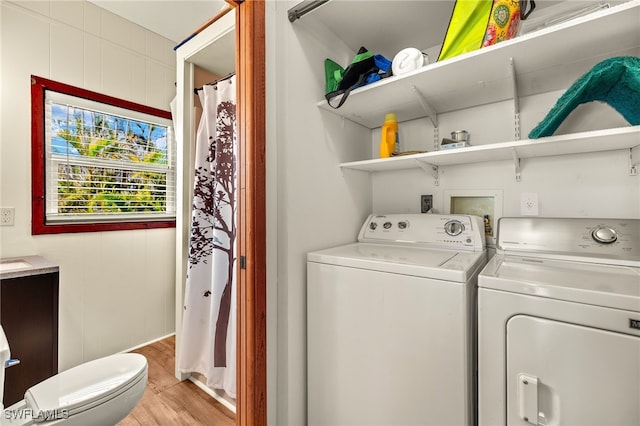 washroom with light wood finished floors and washing machine and dryer