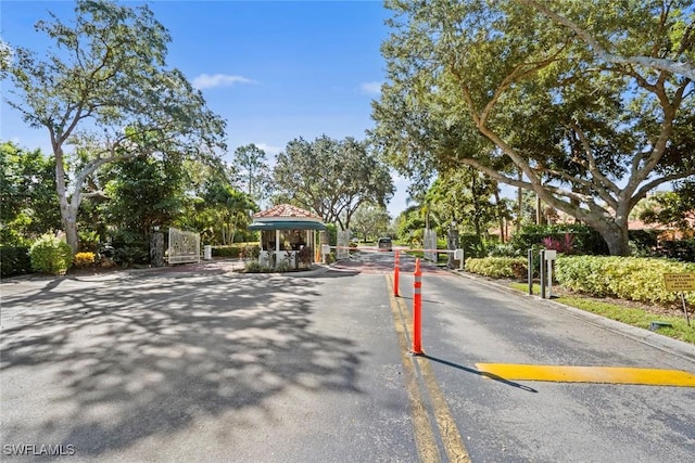 view of street featuring curbs, a gated entry, and a gate