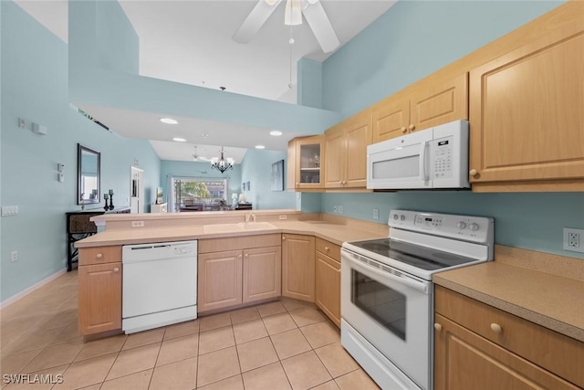 kitchen featuring light countertops, glass insert cabinets, light brown cabinets, white appliances, and a peninsula