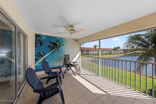 sunroom / solarium featuring a water view and ceiling fan