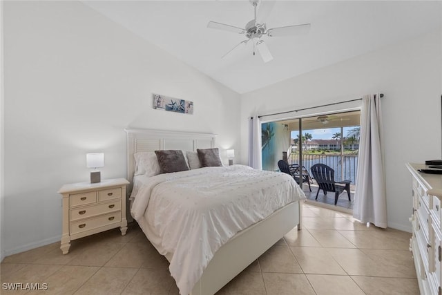 bedroom with a water view, light tile patterned floors, access to outside, and vaulted ceiling