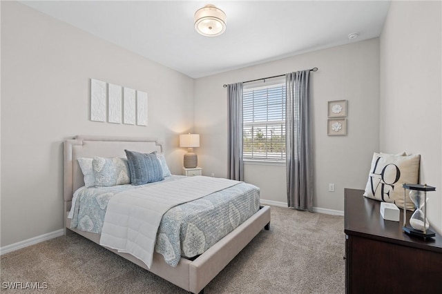 bedroom with baseboards and light colored carpet