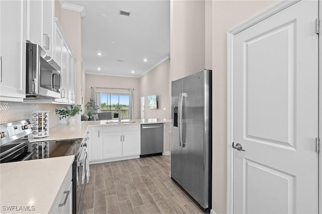 kitchen with stainless steel appliances, white cabinets, light countertops, and a sink