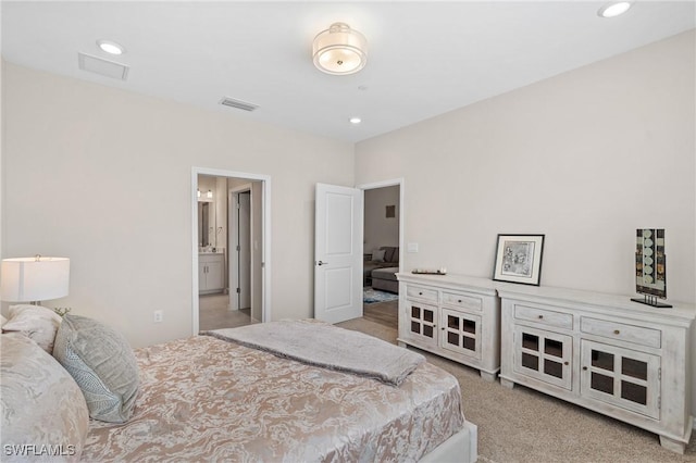 bedroom featuring recessed lighting, visible vents, connected bathroom, and light colored carpet