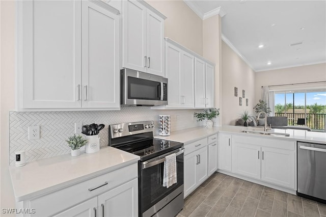 kitchen featuring light countertops, backsplash, appliances with stainless steel finishes, white cabinets, and a sink