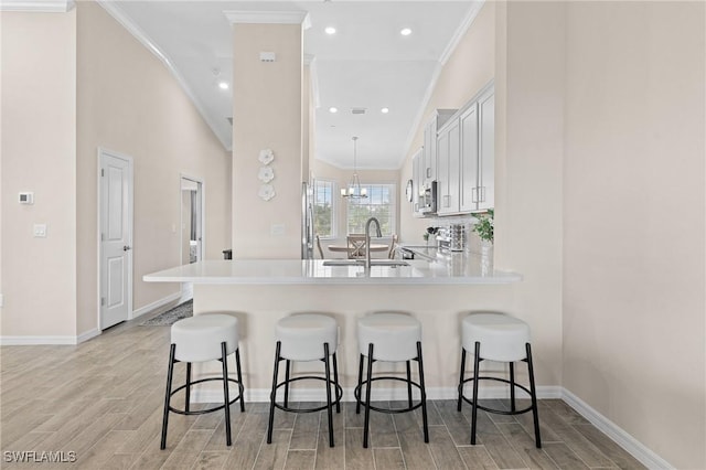 kitchen featuring light countertops, a peninsula, and white cabinets