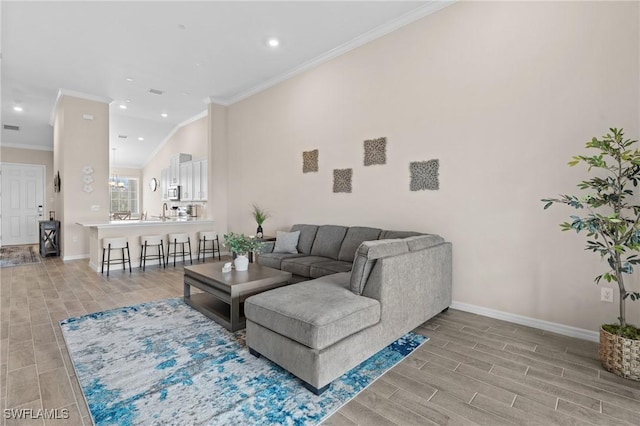 living area featuring ornamental molding, wood tiled floor, and baseboards