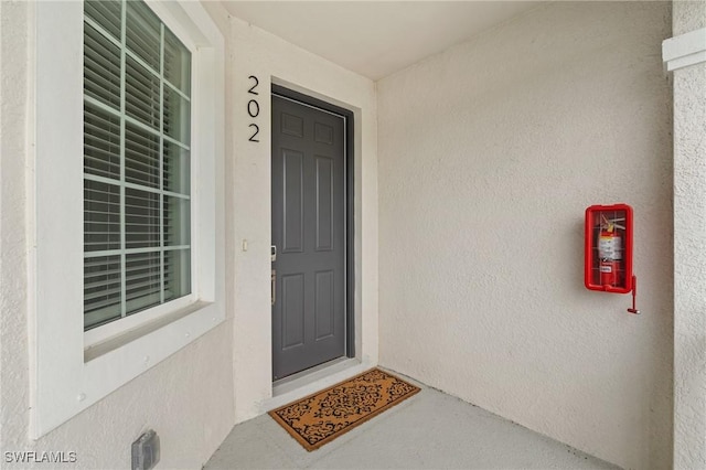 doorway to property featuring stucco siding