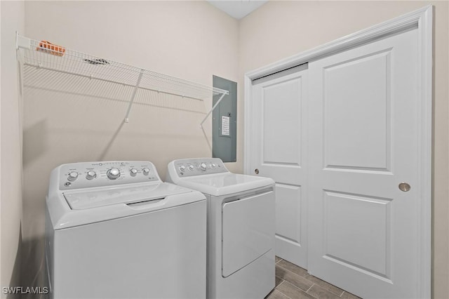 laundry room featuring laundry area, washing machine and clothes dryer, and wood tiled floor