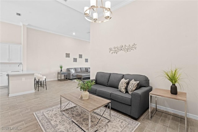 living area featuring wood finish floors, crown molding, visible vents, an inviting chandelier, and baseboards