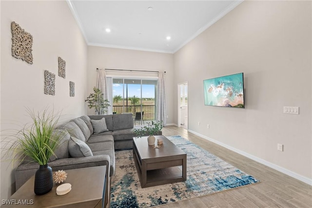 living area featuring baseboards, ornamental molding, wood finished floors, and recessed lighting