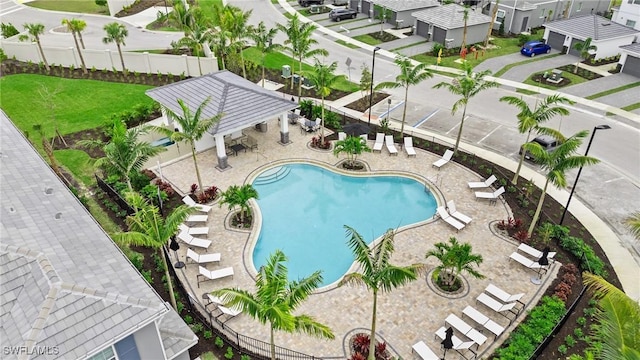 community pool with a patio area and fence