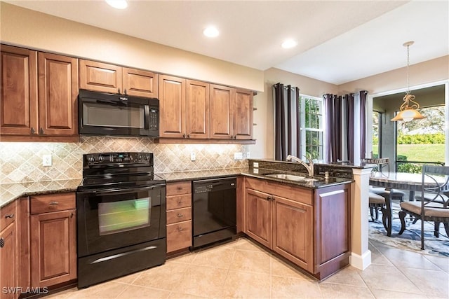 kitchen featuring black appliances, brown cabinetry, and a sink