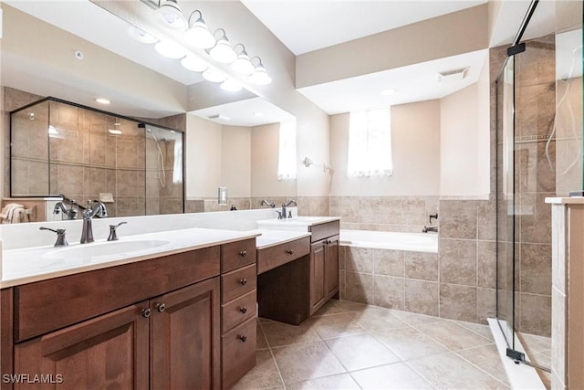 bathroom featuring a garden tub, a sink, visible vents, and tile patterned floors