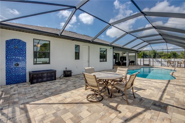 view of swimming pool with a fenced in pool, fence, glass enclosure, a patio area, and outdoor dining area