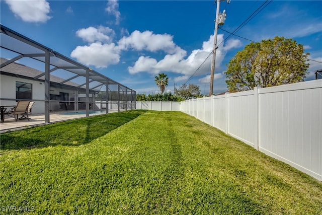 view of yard featuring glass enclosure, a patio, and a fenced backyard