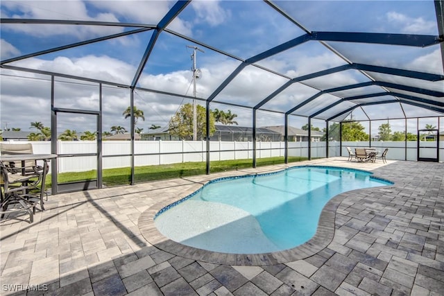 view of swimming pool featuring a lanai, fence, a patio, and a fenced in pool