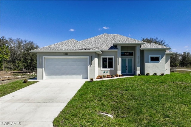 view of front facade with french doors, roof with shingles, a front yard, a garage, and driveway