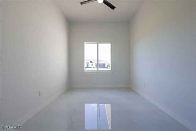 unfurnished room featuring a ceiling fan and baseboards