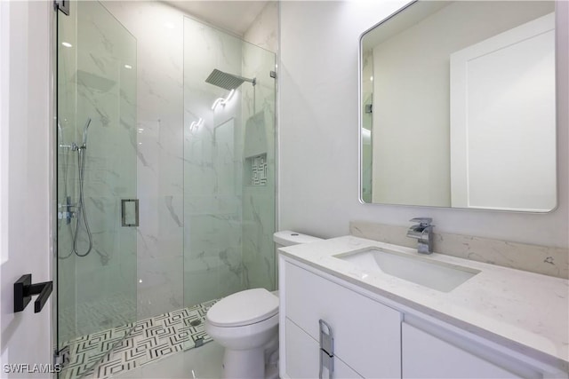 full bath featuring toilet, a marble finish shower, and vanity