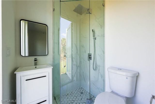 bathroom with toilet, a marble finish shower, and vanity