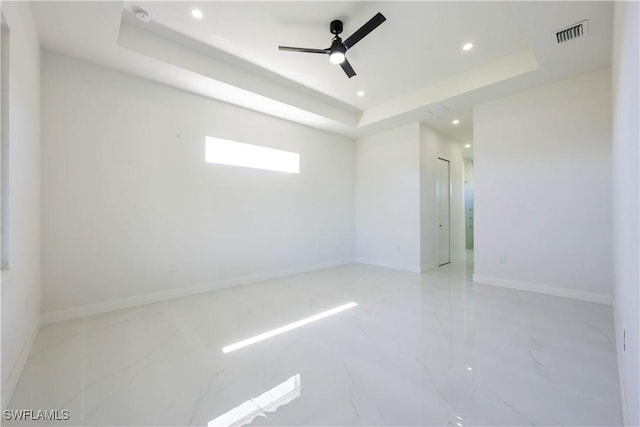 empty room featuring ceiling fan, recessed lighting, visible vents, baseboards, and a tray ceiling