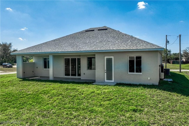 back of property featuring cooling unit, roof with shingles, a yard, and stucco siding