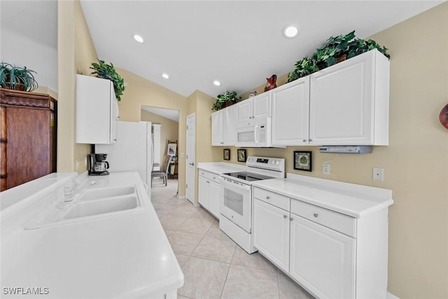 kitchen featuring white appliances, vaulted ceiling, light countertops, white cabinetry, and recessed lighting