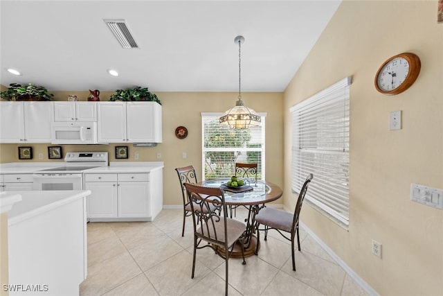 kitchen with white appliances, visible vents, white cabinets, hanging light fixtures, and light countertops